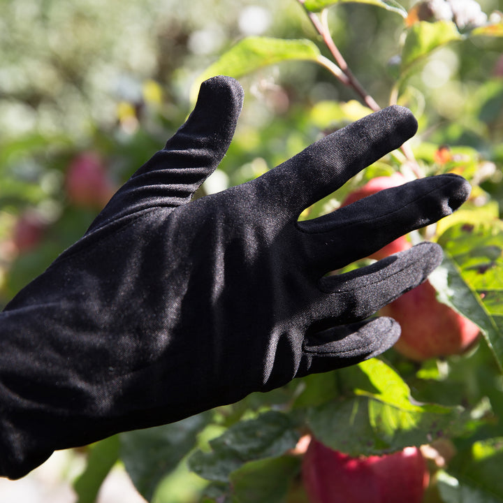 Genus Black Silk glove liners on a person's hand in their garden