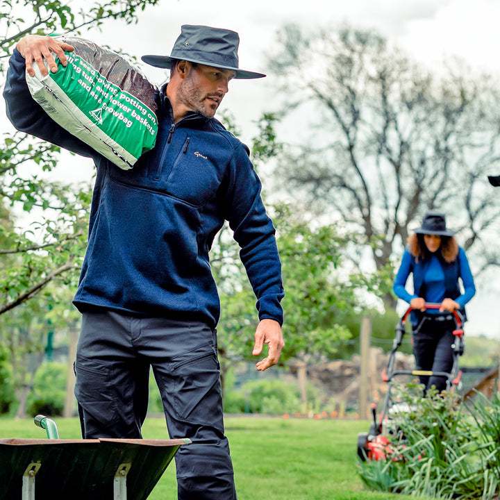 Man and woman in their garden wearing the Genus Showerproof Gardening Hat
