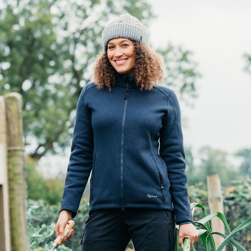 Woman in her garden wearing a Marine Blue Dixter Gardening Jacket